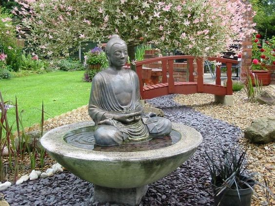 A birdbath with a Buddhist statue that can also work as a small water garden.