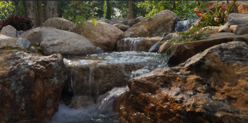 A natural-looking water garden using stepping stone slabs.