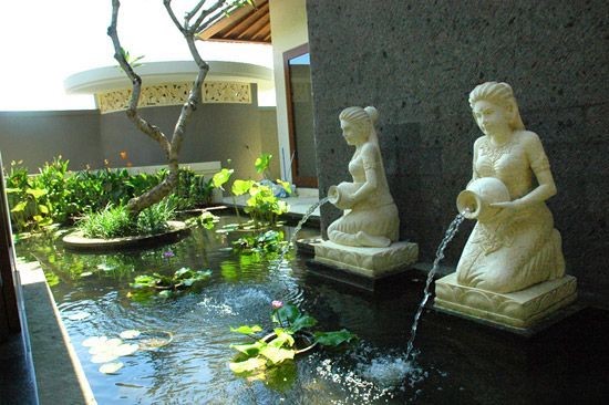 Two maiden statue fountains serve as focal points of the garden, adding an elegant and European ambiance to a water garden.