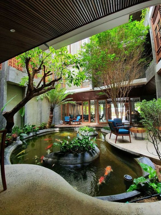 A courtyard filled with indoor trees and a koi pond for a unique indoor experience. 