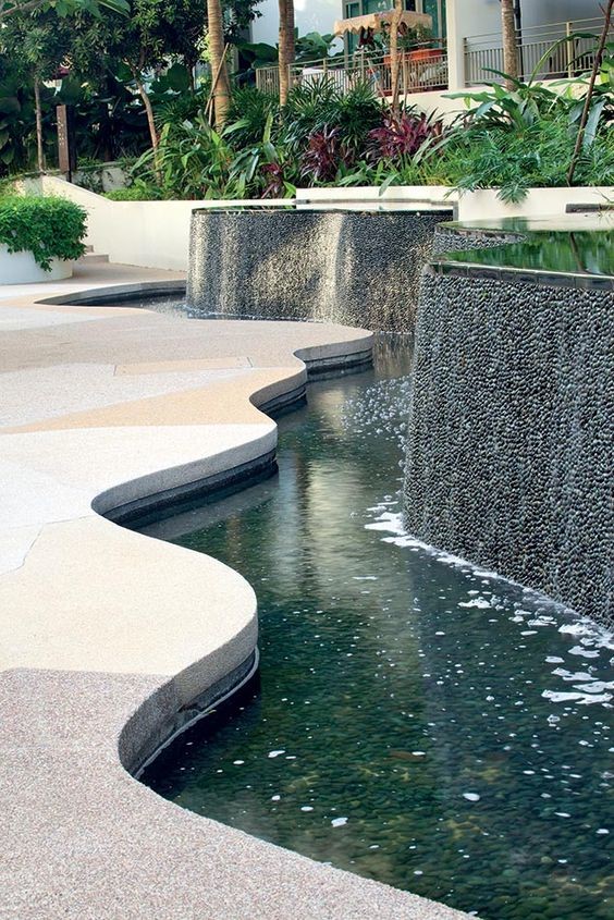  A koi pond that follows the shape of the surrounding water feature as a catch basin. The rigged wall also adds up to the rustling sounds of water that create a relaxing ambiance in a yard. 