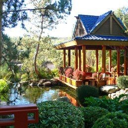 A mini pagoda next to a medium-sized koi pond. 