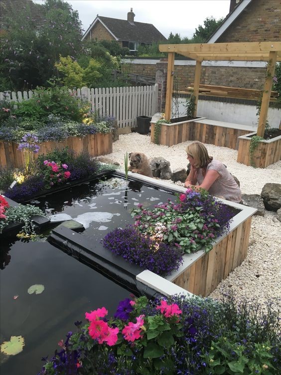 A raised koi pond in the middle of a rock garden. 