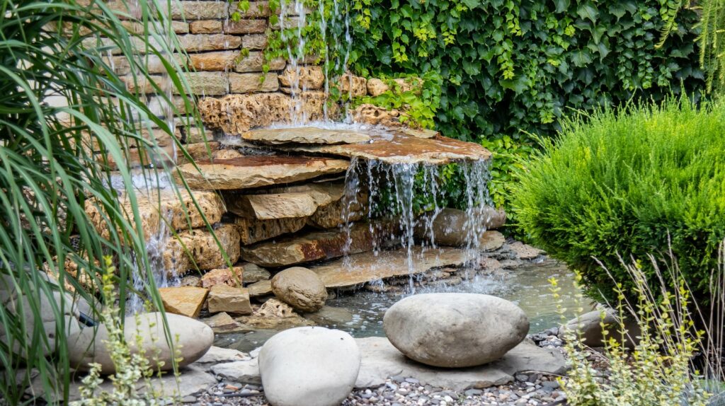 A rock garden that features flat stones in a koi pond.