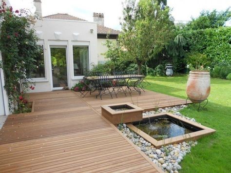 A small koi pond at the edge of the deck or patio with a minimalist touch due to its square-shaped pond frame and rock designs.
