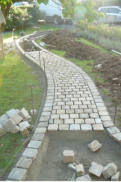 A cobblestone garden path under construction. 