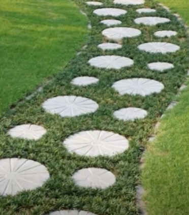 A flower-shaped stepping stone in a garden path.