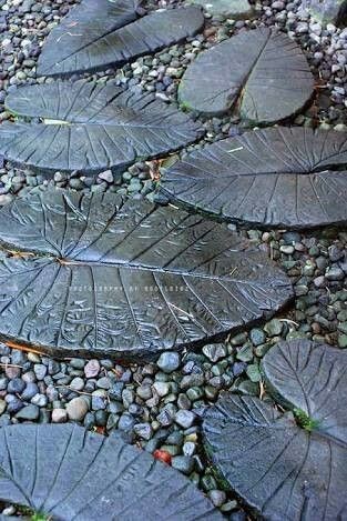 A pathway made of dark-colored concrete leaves.
