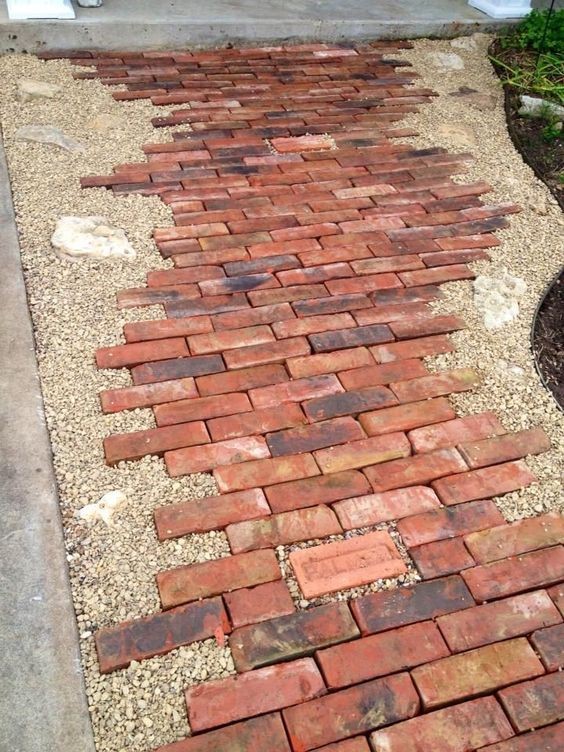 A font garden pathway where the path is made of the irregular pattern of colonial bricks.