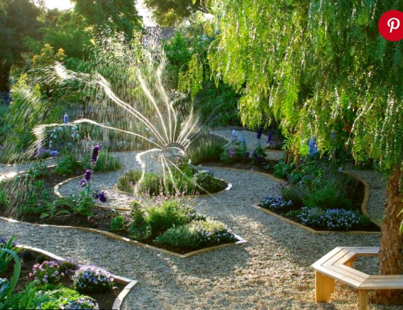 A unique pathway design where the planters are placed around the water sprinkler.