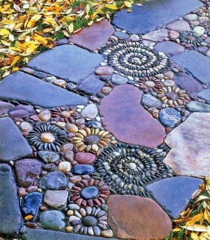 A garden path design that combines the concepts of flat-surfaced blue rocks and pebbles.