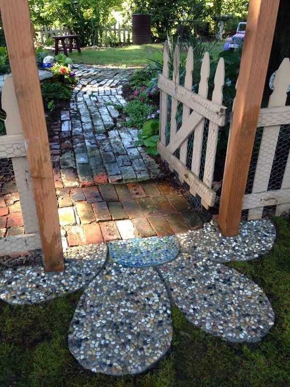 A beautiful flower mosaic placed at the start of the bricked garden path.