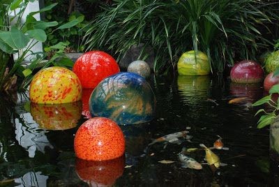 Some glass balls floating around a koi pond 