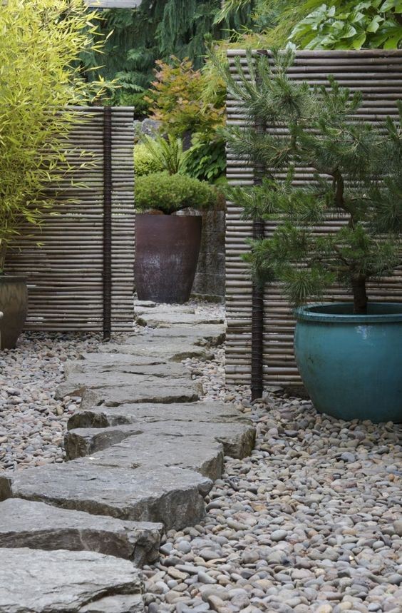 The bluestone slabs create the main garden path leading to a hidden part of the garden covered by a bamboo fence.