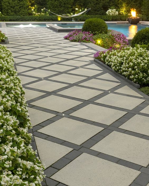 A neat-looking garden path placed next to a swimming pool.