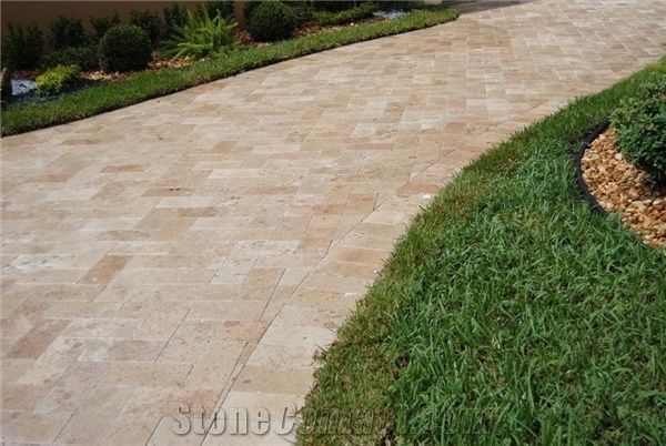 The neutral colors of the travertine help create a luxurious pathway on the lawn