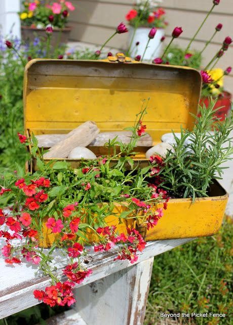 Old storage bins as fence planters.