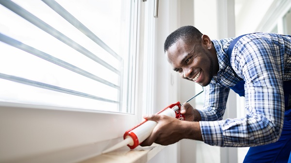 Weatherstripping or sealing a window.